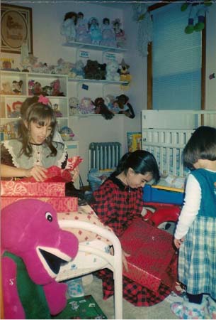 Danielle opening her gift in a room full of toys